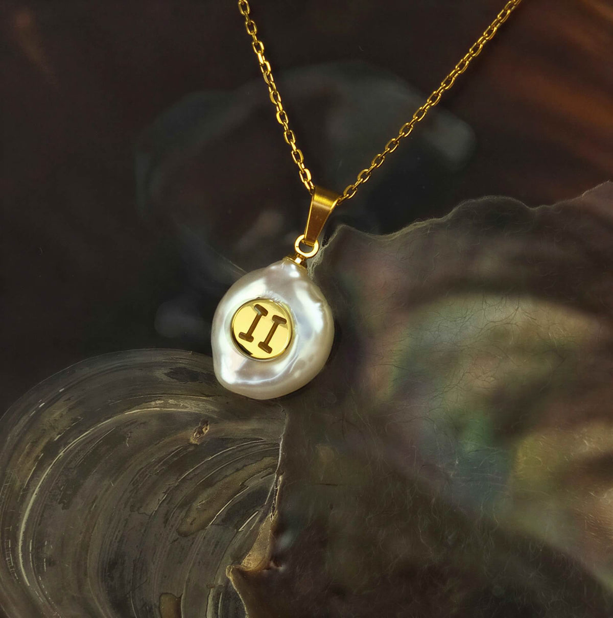 Witte zoetwater parelketting met hanger en symbool van sterrenbeeld Tweeling en goud edelstaal liggend in schelp | Gouden Sterrenbeeld Tweeling