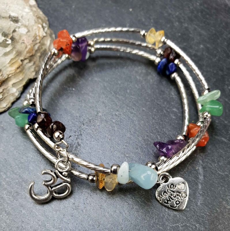 Edelstenen wikkelarmband met veel soorten en kleuren edelstenen en aum teken liggend op leisteen | Gemstone 3 Loops Ohm