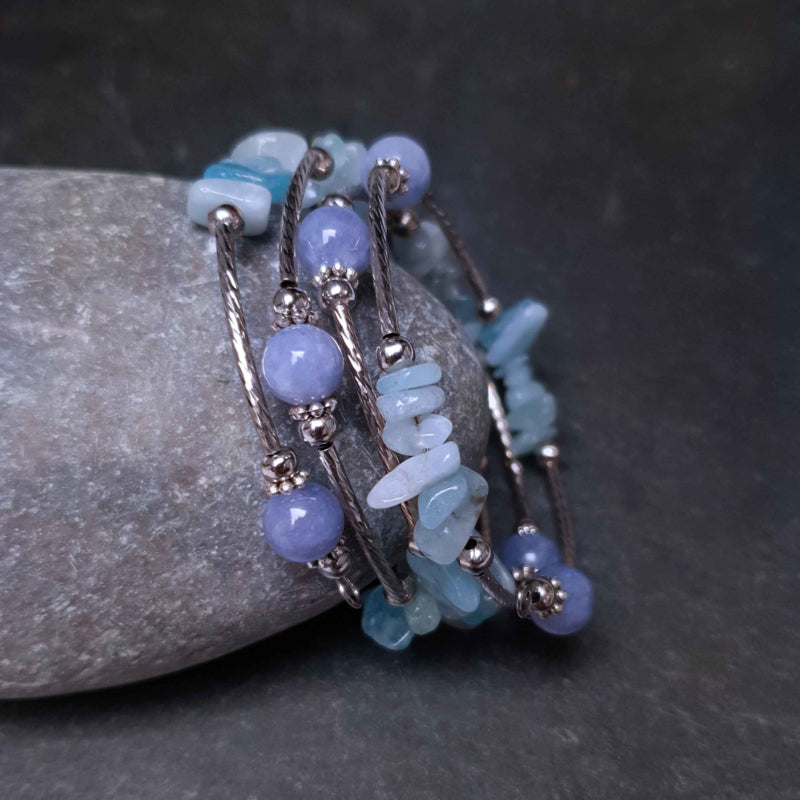 Blauw edelstenen wikkelarmband met aquamarijn en aventurien liggend tegen steen | Four loops Wrap Blue Gemstone
