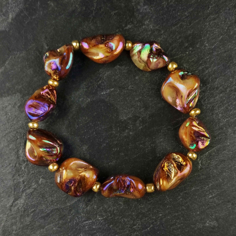 Bruin parelmoeren schelpen armband met goud edelstaal liggend op leisteen bovenaanzicht | set Shell AB Brown Gold