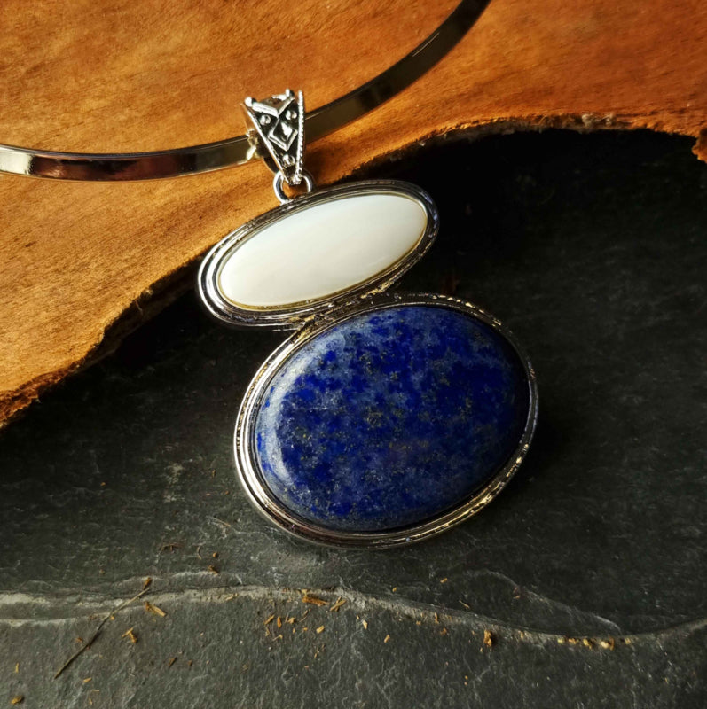 Blauwe edelstenen ketting met lapis lazuli en wit parelmoeren hanger liggend tegen hout | Lapis Lazuli & White Shell