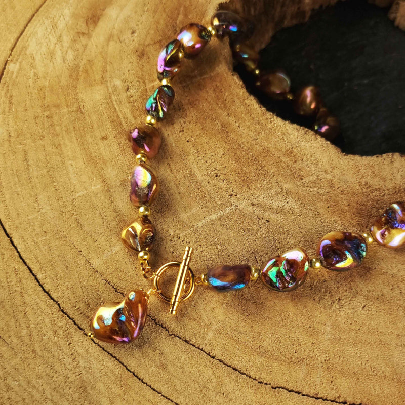 Slotje van bruin parelmoeren schelpen ketting met goud edelstaal liggend op hout | Shell AB Brown Gold