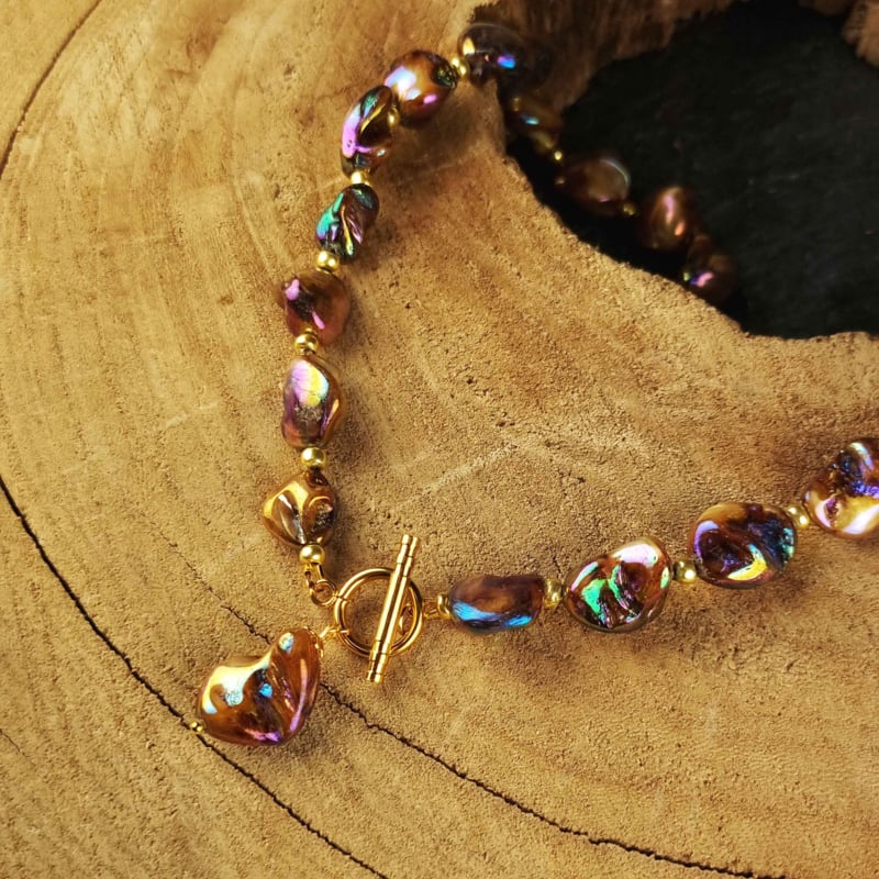 Slotje van bruin parelmoeren schelpen ketting met goud edelstaal liggend op hout | set Shell AB Brown Gold