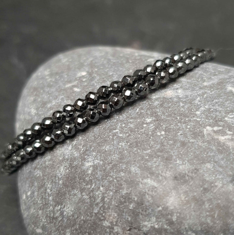 Zwart edelstenen wikkelarmband met hematiet liggend op kei | Hematite Wrap Sparkle
