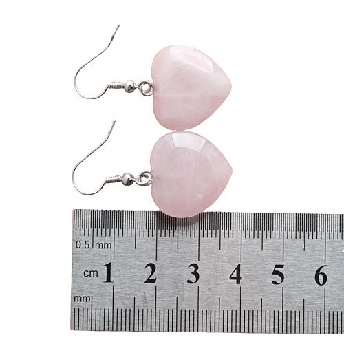 Roze edelstenen oorbellen met rozenkwarts in hartjes vorm en sterling zilver (925) liggend naast lineaal | Rosé Love