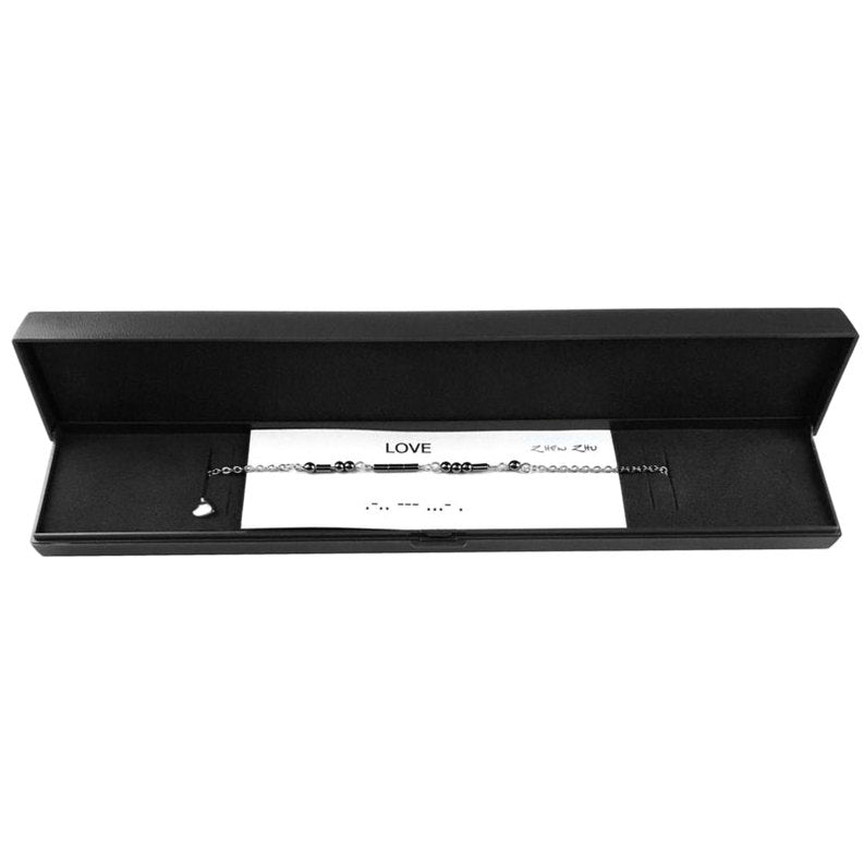 Zwarte edelstenen ketting met zilver edelstaal en hematiet stenen die het woord LOVE in morse code weer geeft liggend in sieraden doosje | Morse Code Love Black Hematite Silver