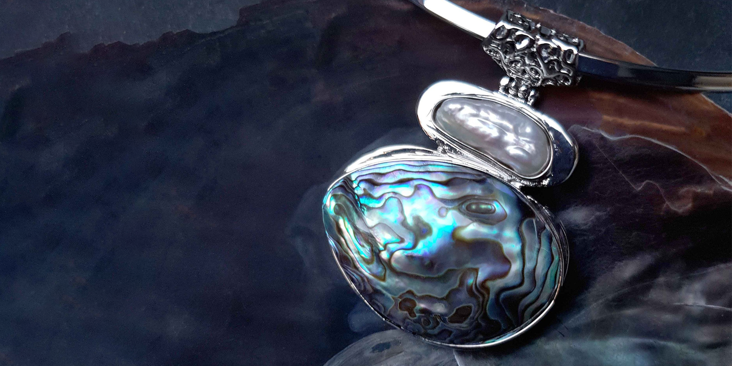 Ketting met abaloon en zoetwaterparel liggend in schelp