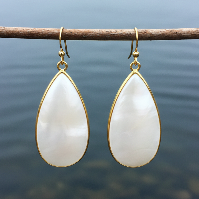 Witte parelmoeren oorbellen met goud edelstaal hangend aan takje boven water | Big Taerdrop White Shell Gold