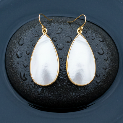 Witte parelmoeren oorbellen met goud edelstaal liggend op steen in water | Big Taerdrop White Shell Gold