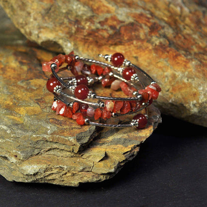 Rood edelstenen wikkelarmband met rode agaat liggend op steen | Four Loops Wrap Red Agate