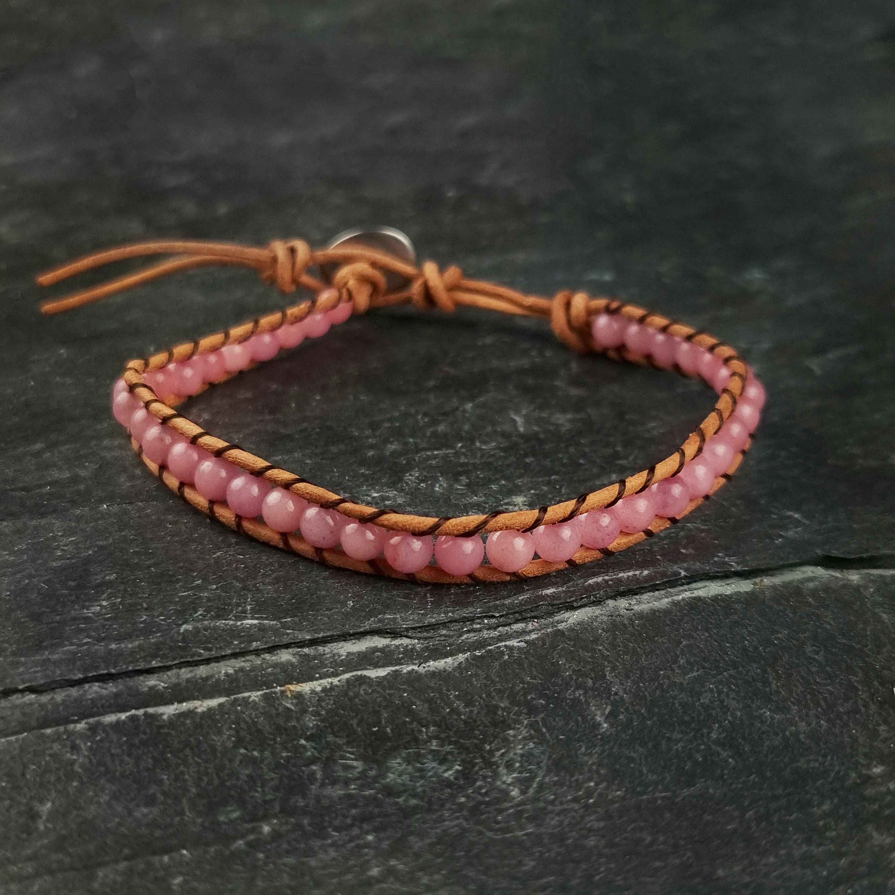 Roze edelstenen armband met rozenkwarts en bruin leer liggend op leisteen | Wrap Little Rose Quartz