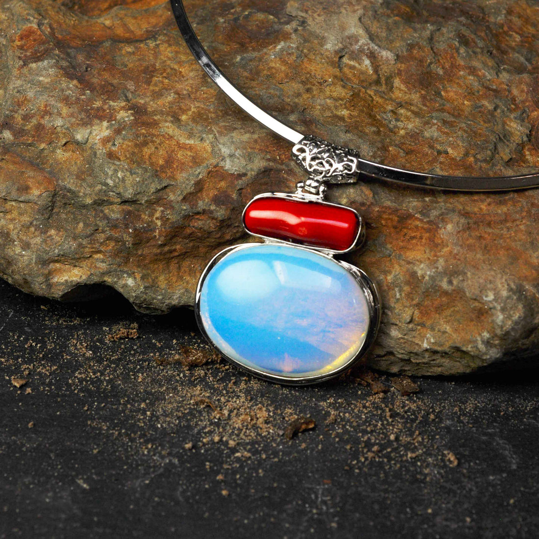 Detail van edelstenen ketting met zee opaal en koralen hanger liggend op steen | Sea Opal Coral