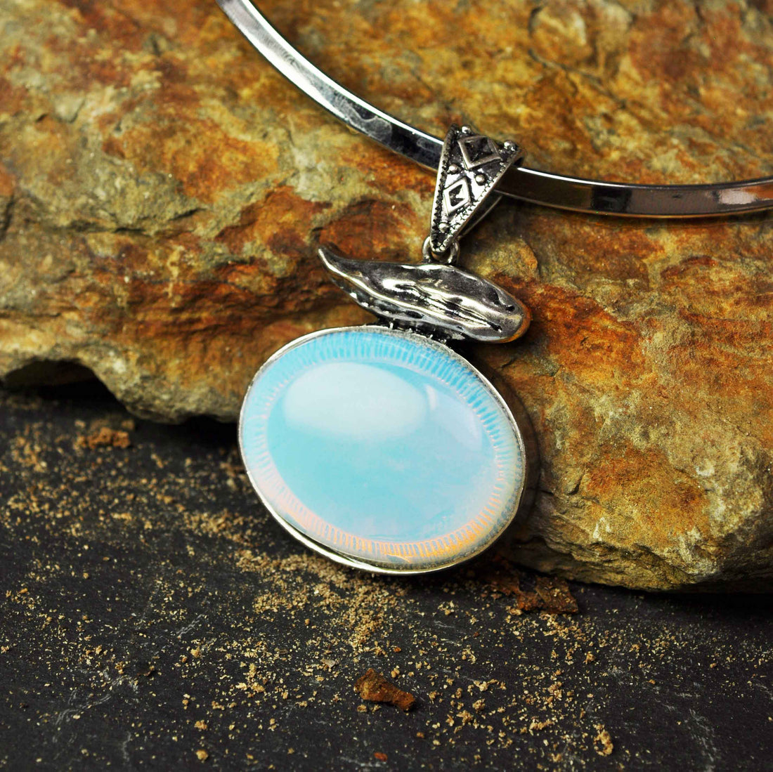 Detail van blauwe edelstenen ketting met zee opaal liggend tegen bruine steen | Sea Opal Choker