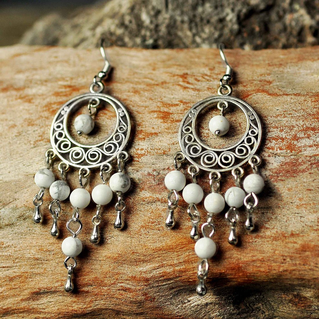 Witte edelstenen oorbellen met sterling zilver (925) en howliet liggend op hout | Oriental Howlite