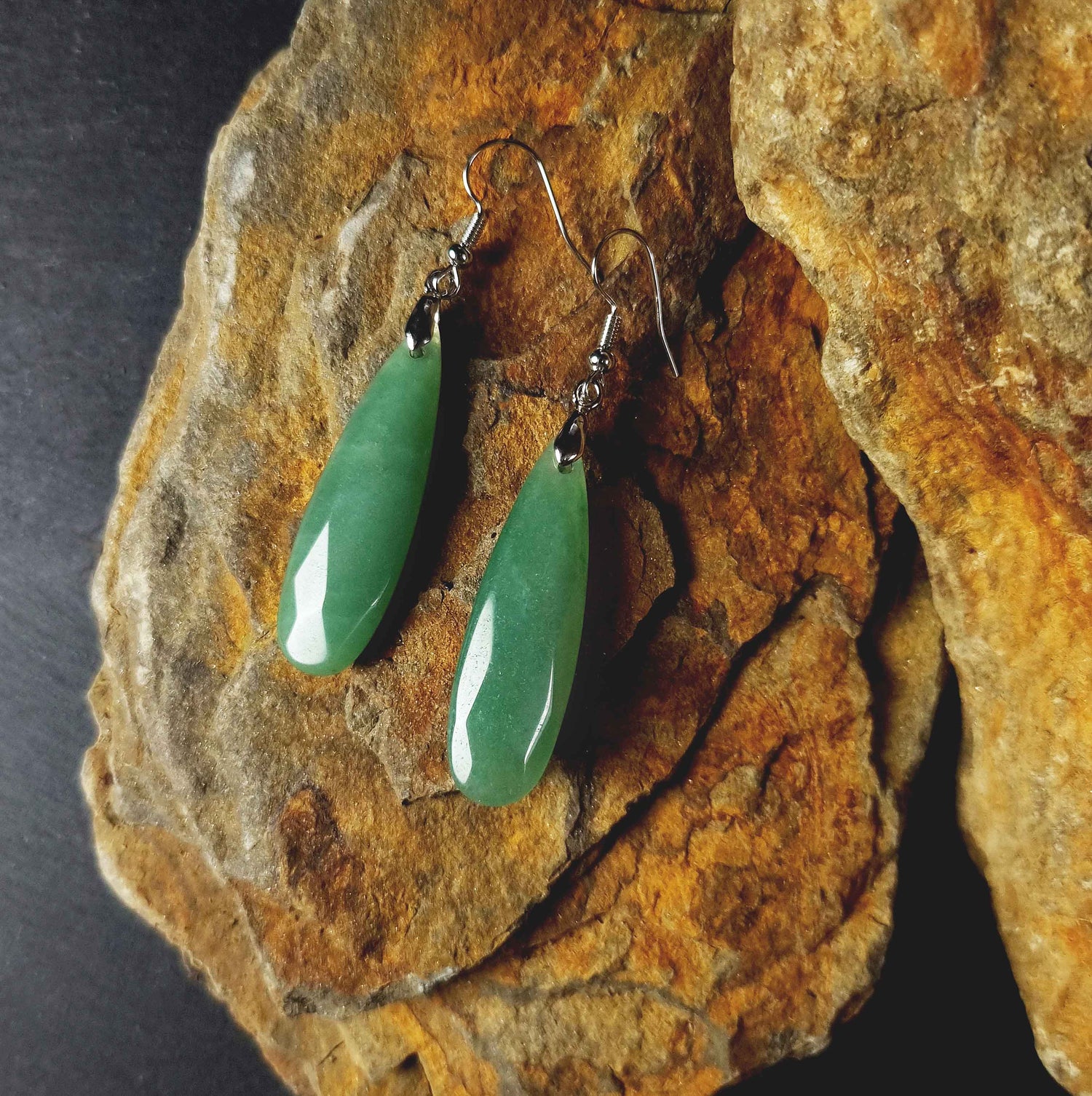 Groene edelstenen oorbellen met aventurien en sterling zilver (925) liggend op steen | Big Long Drop Green Aventurine
