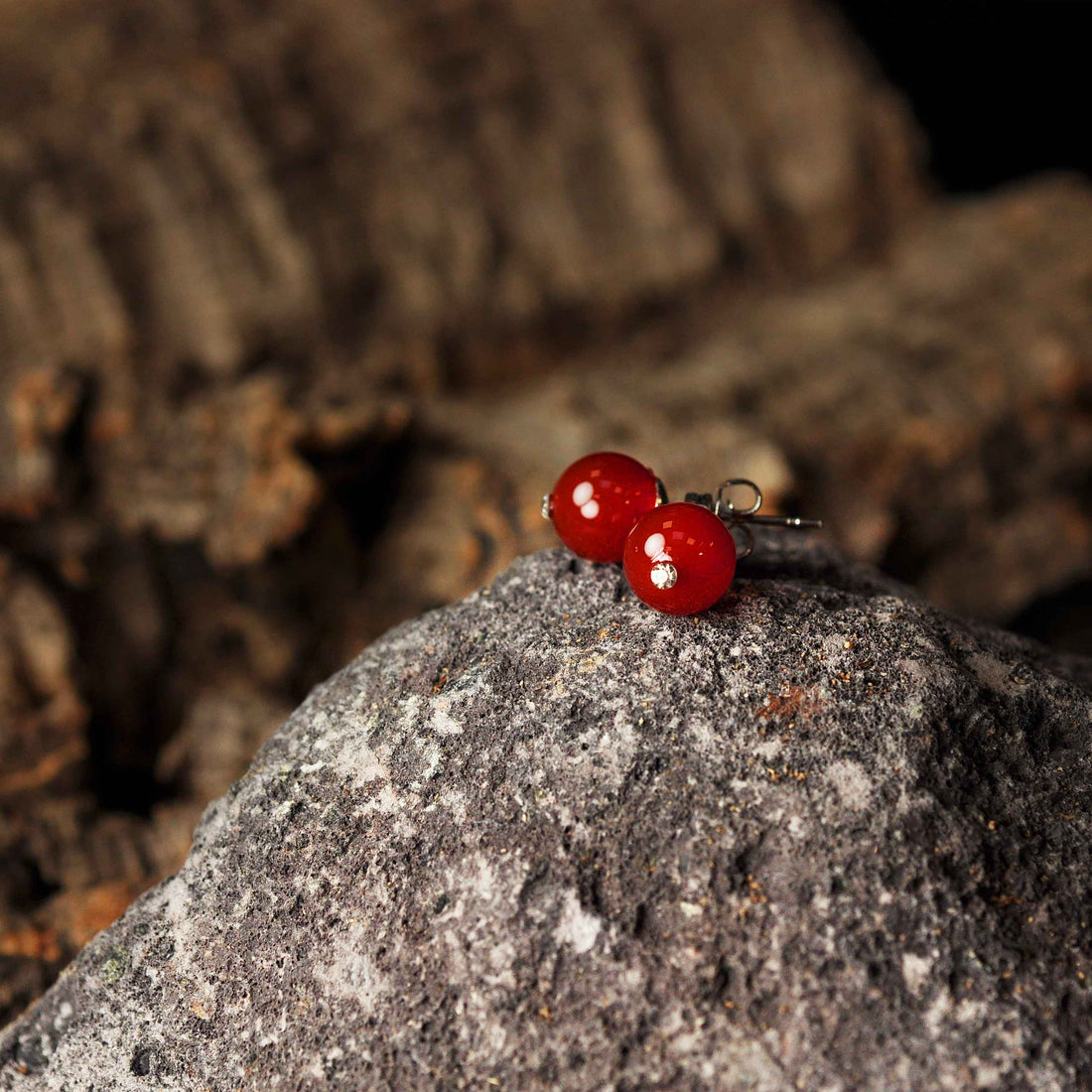 Rode edelstenen oorbellen met agaat, rode edelstenen oorknopjes liggend op steen | Bling Red Agate