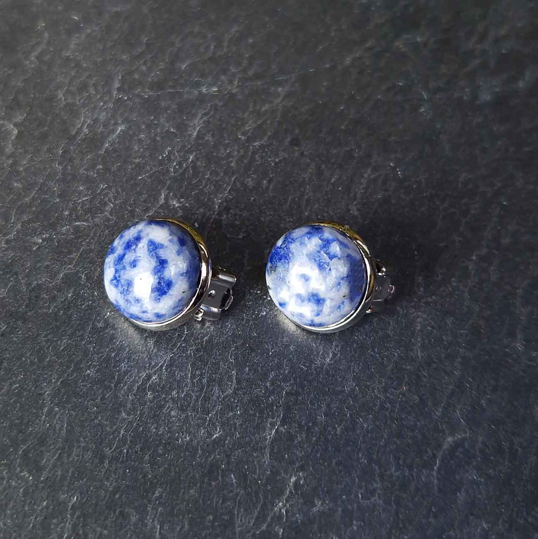 Blauwe edelstenen clips oorbellen met blus spot jaspis liggend op leisteen | Blue Spot Clips