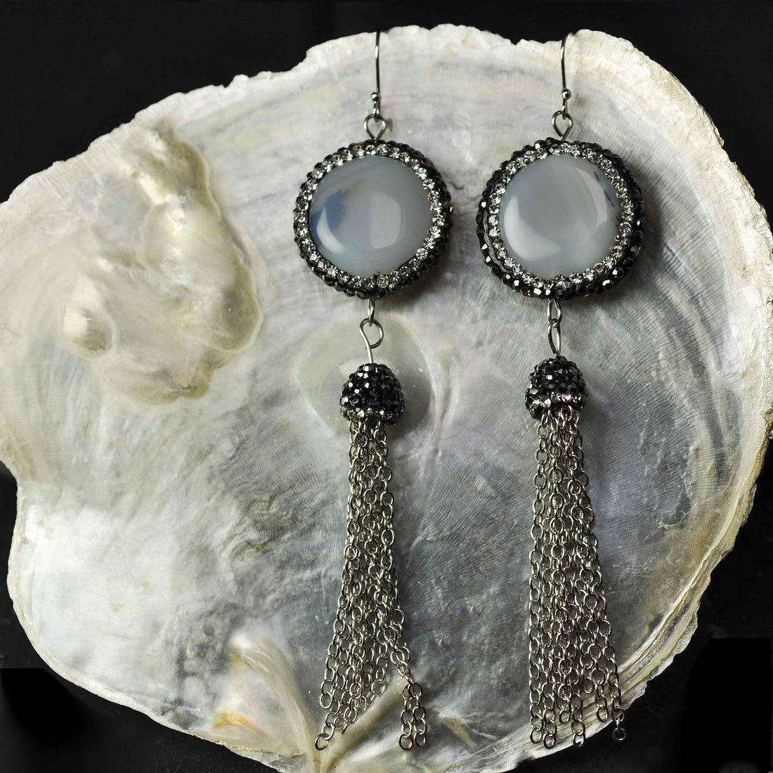 Lange grijze edelstenen oorbellen met agaat, stras steentjes, sterling zilver en kwastje ander paar oorbellen hangend aan witte schelp | Bright Nature Agate Tassel