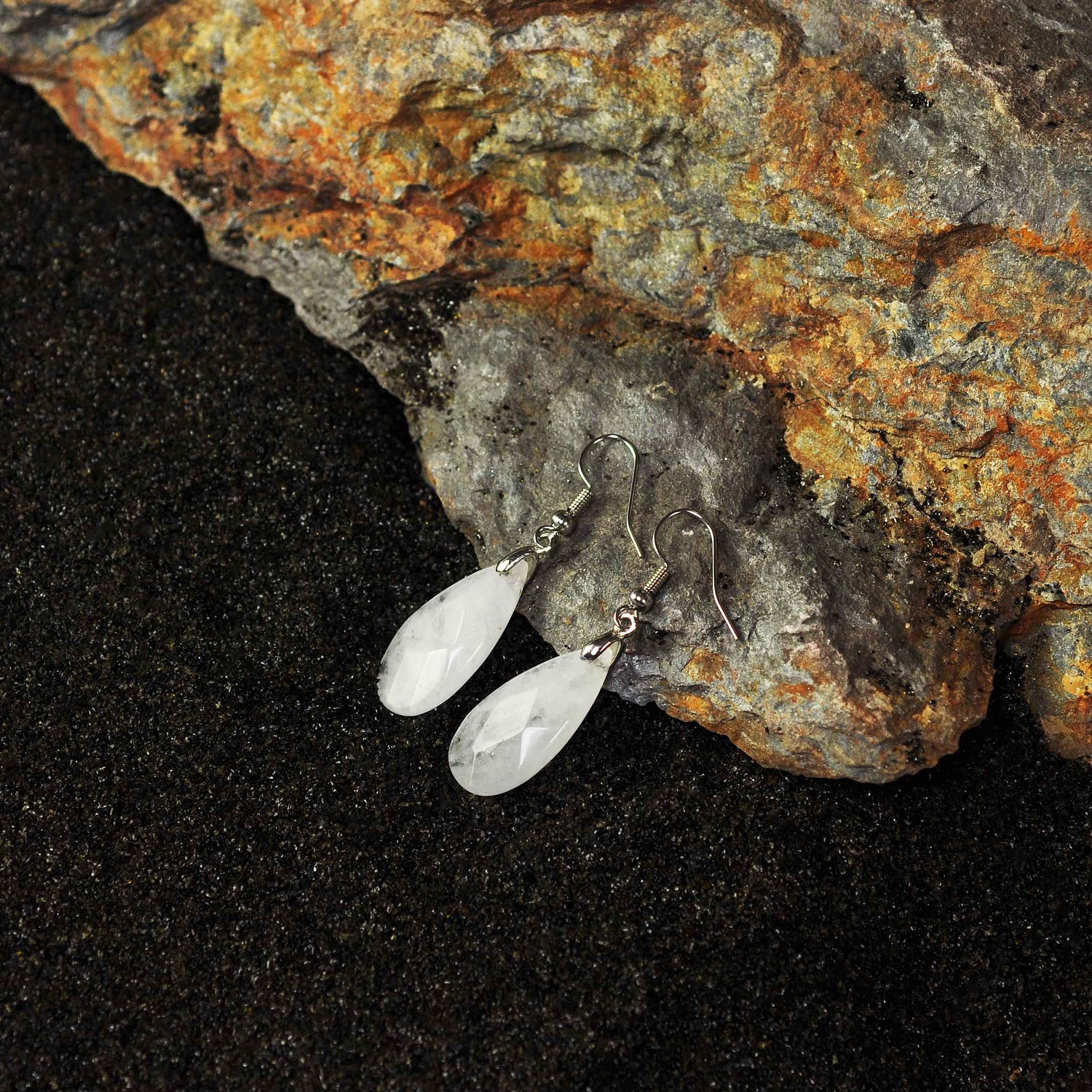 Edelstenen oorbellen met bergkristal en sterling zilver (925) met achtergrond zwart zand | Facet Clear Crystal