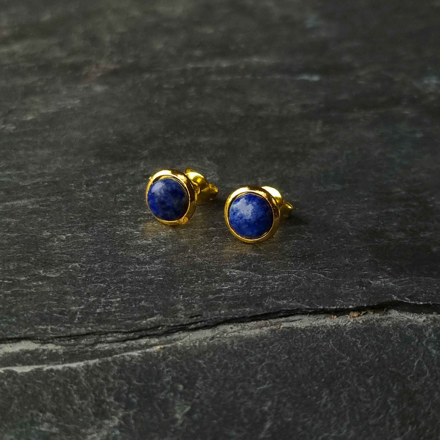 Blauwe edelstenen oorbellen met lapis lazuli, lapis lazuli oorknopjes liggend op leisteen, vooraanzicht | Lapis Lazuli Small Gold