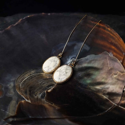 Lange edelstenen oorbellen met howliet en goud hangend in schelp| Long Howlite Gold