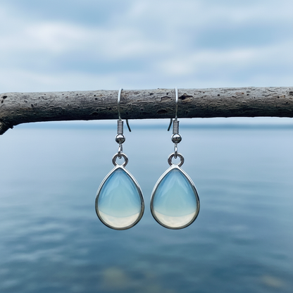 Licht blauwe edelstenen oorbellen met zee opaal en oorbelhaakjes van sterling zilver (925) hangend aan een takje | Sea Opal Teardrop