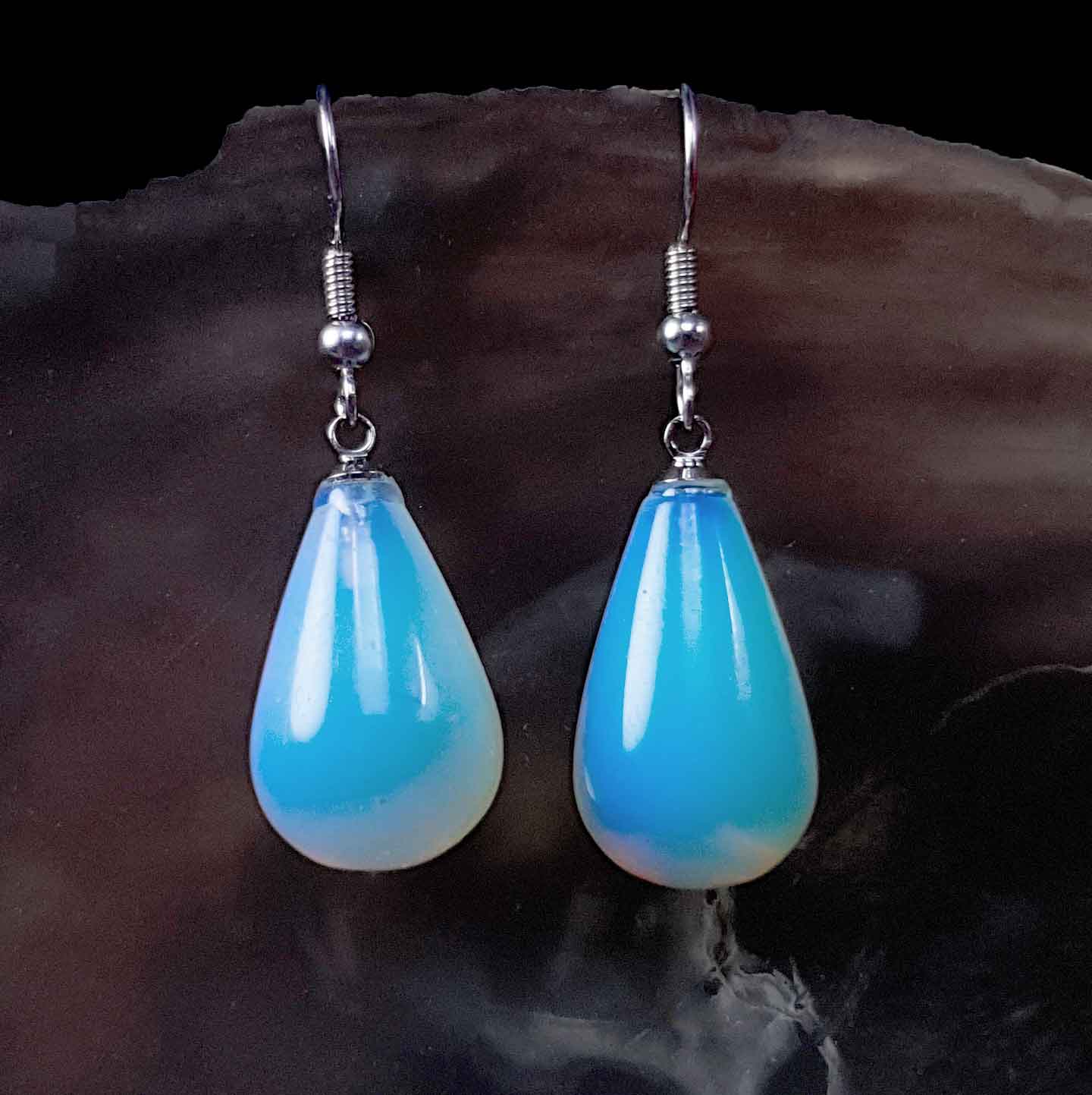 Blauwe edelstenen oorbellen met zee opaal en sterling zilveren oorbelhaakjes hangend aan bruine schelp  Sea Opal Big Drop