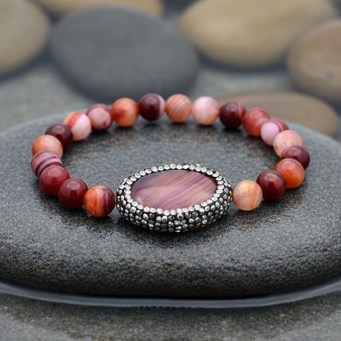 Rood edelstenen armband met agaat en stras steentjes liggend op steen, elastisch | Bling Oval Red Striped Agate