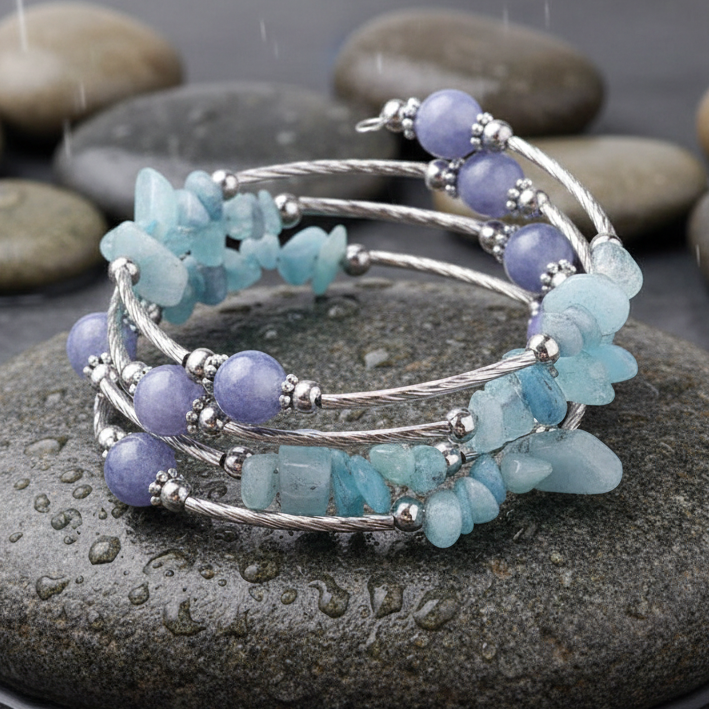 Four Loops Wrap Blue Gemstones edelstenen wikkelarmband close-up op grijze natte steen bij oever