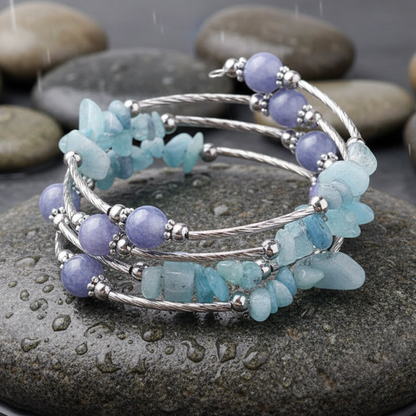 Four Loops Wrap Blue Gemstones edelstenen wikkelarmband close-up op grijze natte steen bij oever