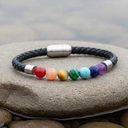 Edelstenen armband met met veel kleuren en soorten edelstenen en zwart leer liggend op beige steen | Gemstone Rainbow Black Leather