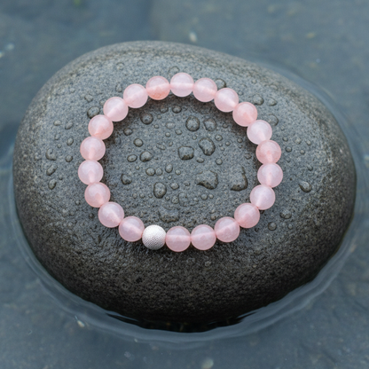 Bovenaanzicht rozenkwarts armband op grijze steen