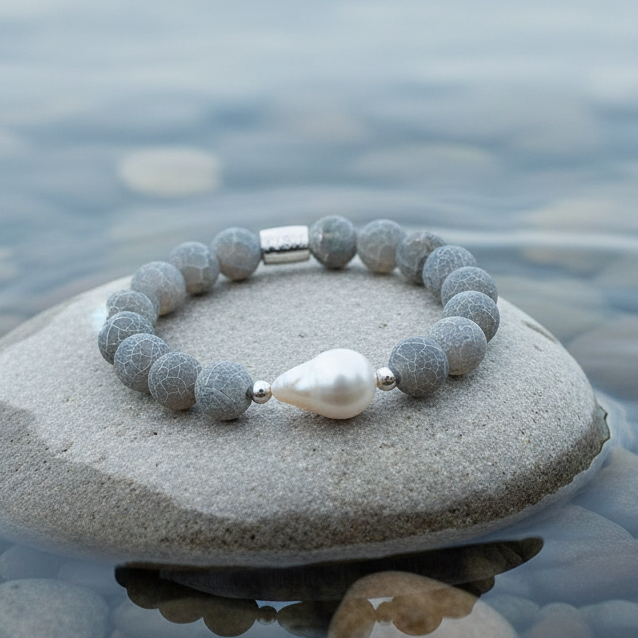 Zoetwater parel armband met witte parel en grijze edelsteen agaat, elastisch liggend op steen in water | Frozen Grey Agate White Pearl