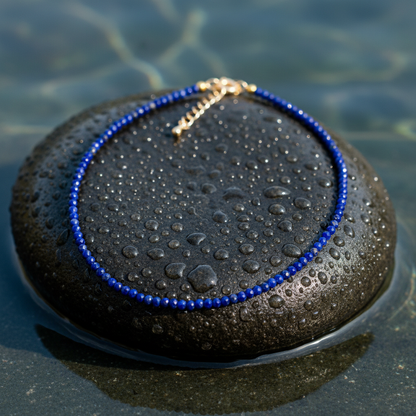 Blauw edelstenen armband met facet geslepen lapis lazuli en goud edelstaal liggend op steen in water | Lapis Lazuli Mini