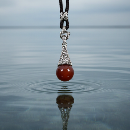 Rode edelstenen ketting met stras steentjes en agaat hangend boven water | Red Agate Bling