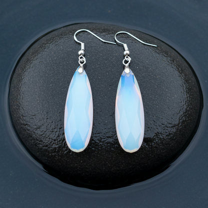 Lange licht blauwe edelstenen oorbellen met opaal en sterling zilver (925) liggend op steen in water | Big Long Drop Sea Opal