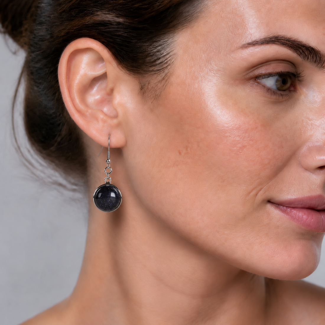 Blauw zwarte edelstenen oorbellen met goudsteen en sterling zilver (925) op model | Blue Goldstone Round