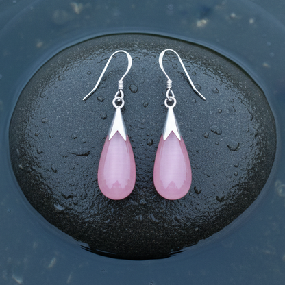 Roze edelstenen oorbellen met kattenoog en sterling zilver (925) liggend op steen in water | Cat&