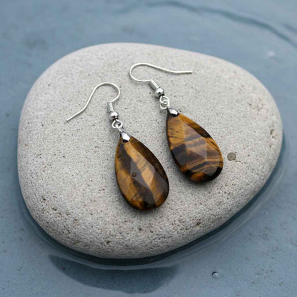 Bruine edelstenen oorbellen met tijgeroog en sterling zilver (925) liggend op steen in water | Facet Tiger Eye