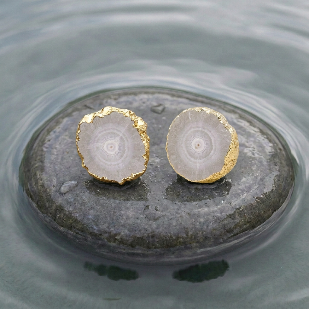 Grijze edelstenen oorbellen met kwarts  en goud liggend op natte steen in water | Iris grijs