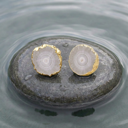 Grijze edelstenen oorbellen met kwarts  en goud liggend op natte steen in water | Iris grijs