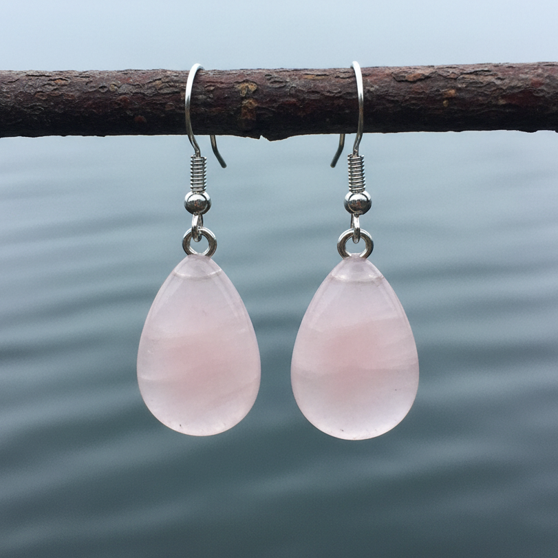 Roze edelstenen oorbellen met rozenkwarts in druppel vorm en sterling zilver (925) hangend aan takje boven water | Rosé Quartz Drop
