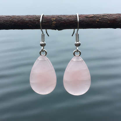 Roze edelstenen oorbellen met rozenkwarts in druppel vorm en sterling zilver (925) hangend aan takje boven water | Rosé Quartz Drop