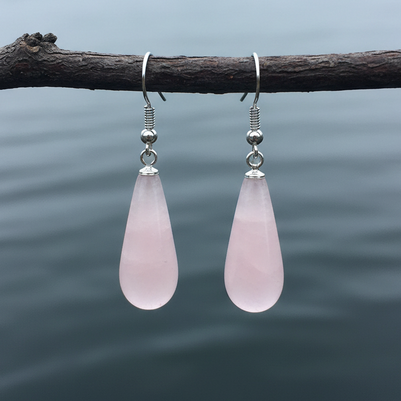 Roze edelstenen oorbellen met rozenkwarts in lange druppel vorm en sterling zilver (925) hangend aan takje boven water | Rosé Quartz Long Drop