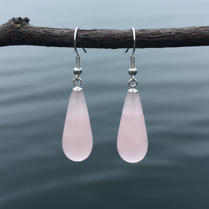 Roze edelstenen oorbellen met rozenkwarts in lange druppel vorm en sterling zilver (925) hangend aan takje boven water | Rosé Quartz Long Drop