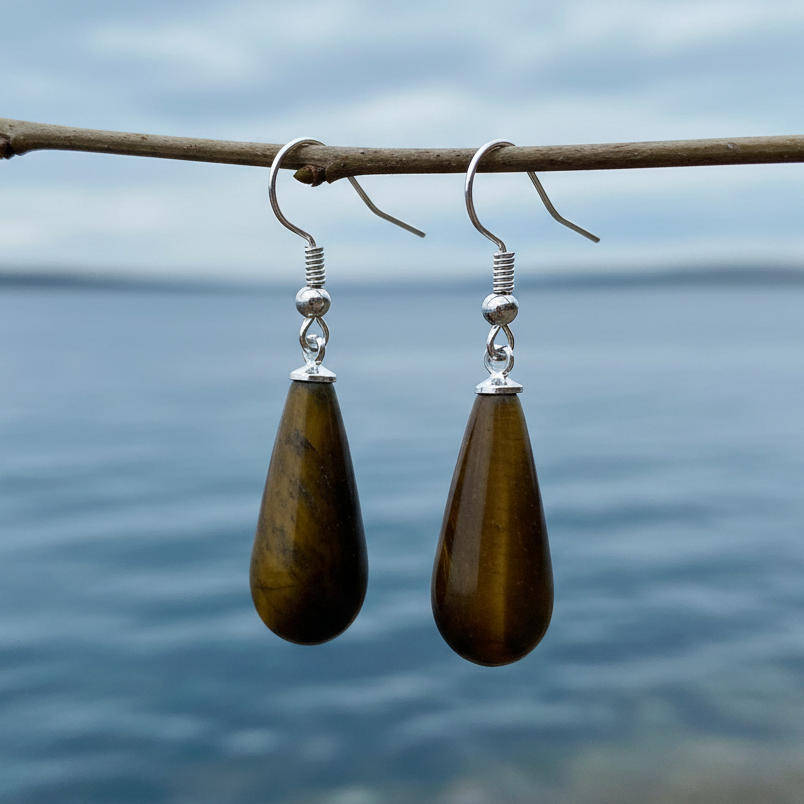 Tiger Eye oorbellen aan takje bij waterrand