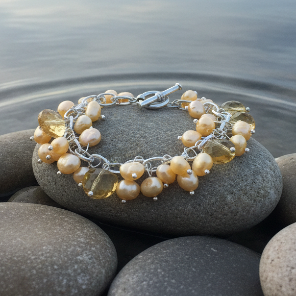 Geel zoetwater parel armband met parel bedeltjes en geel kristal liggend aan de waterrand | Sunny
