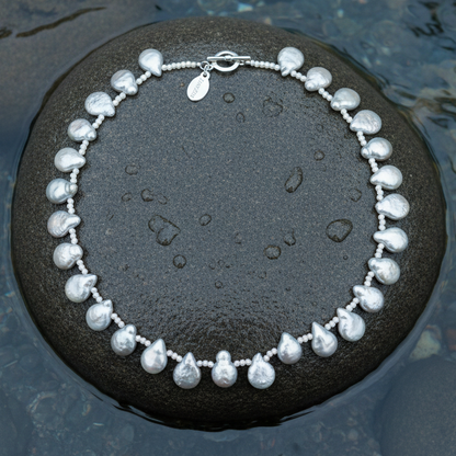 Zoetwater parelketting met grijze parels  liggend op steen in water | Little Grey Coin