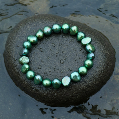 Groen zoetwaterparel armband liggend op steen in water, elastisch | Green Pearl