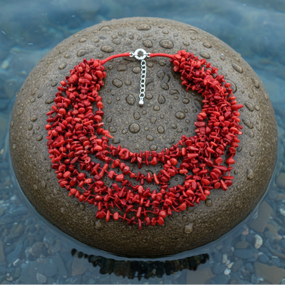 Rood koralen ketting met 8 strengen rood koraal liggend op steen | Big Coral Chip